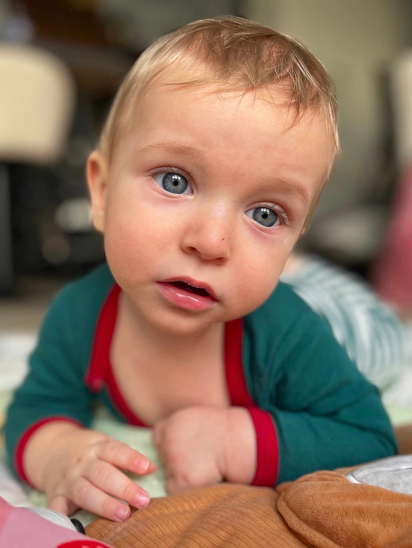 Dayann participe au concours pour gagner de l'argent avec cette photo : baby, child, blue_eyes, close_up, cute, infant, laying, soft_toys, indoors, portrait, curious, clothing, hand, face, skin, young, person, expression, background_blur, cozy