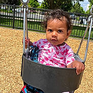 Xamira joined the competition — help win amazing prizes! toddler, child, swing, playground, outdoor, curly_hair, pink_clothing, heart_pattern, blanket, wood_chips, fence, trees, sunny_day, park, hand, face, expression, seat, metal_chain, nature