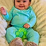 baby, infant, smile, curly_hair, turquoise_clothing, fuzzy_boots, green_toy, blanket, cozy, indoors, happy, child, cute, soft_texture, portrait, sitting, warm, home, comfortable, teething_toy