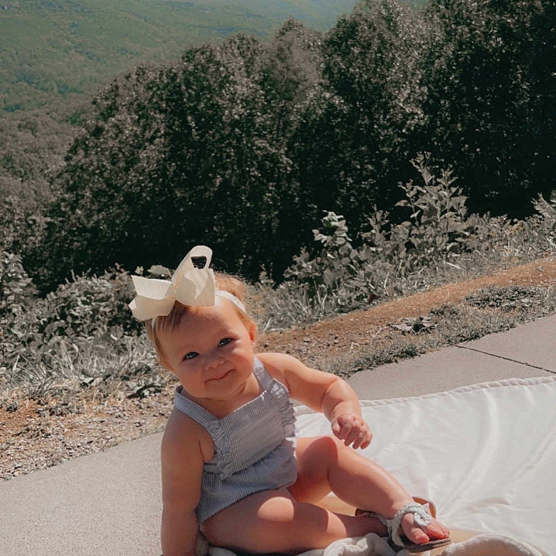 Adelynn joined the competition — help win amazing prizes! baby, beachwear, clothing, dress, face, hat, head, outdoors, person, photography, plant, portrait, rock, shorts, sitting, soil, summer, sunhat, tree, vegetation