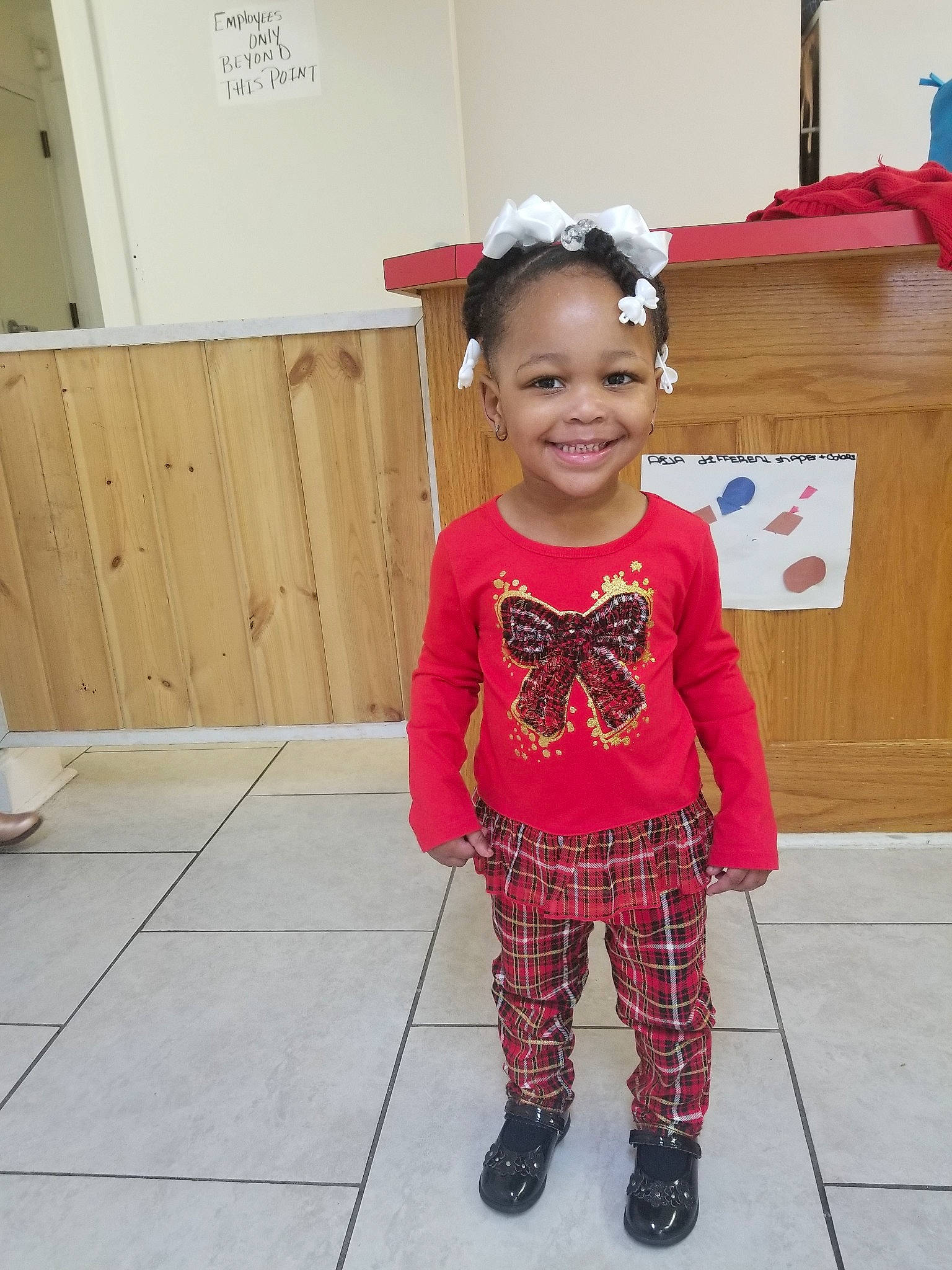 Rhiley is registered to the contest to win money with this photo: child, clothing, day, design, flooring, footwear, fun, girl, joy, outerwear, pattern, person, pink, product, red, shoulder, sleeve, smile, standing, t_shirt