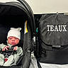 baby, backpack, black, bundle, car_seat, child, clothing, comfortable, cute, expression, face, hat, indoor, infant, newborn, person, seatbelt, small, soft, text