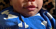 Markus is registered to the contest to win money with this photo: baby, blanket, blue_onesie, child, closeup, cloud_pattern, curious, cute, eyes, face, happy, heart_emoji, indoors, infant, leopard_print, lying_down, portrait, smiling, soft_texture, sun_pattern