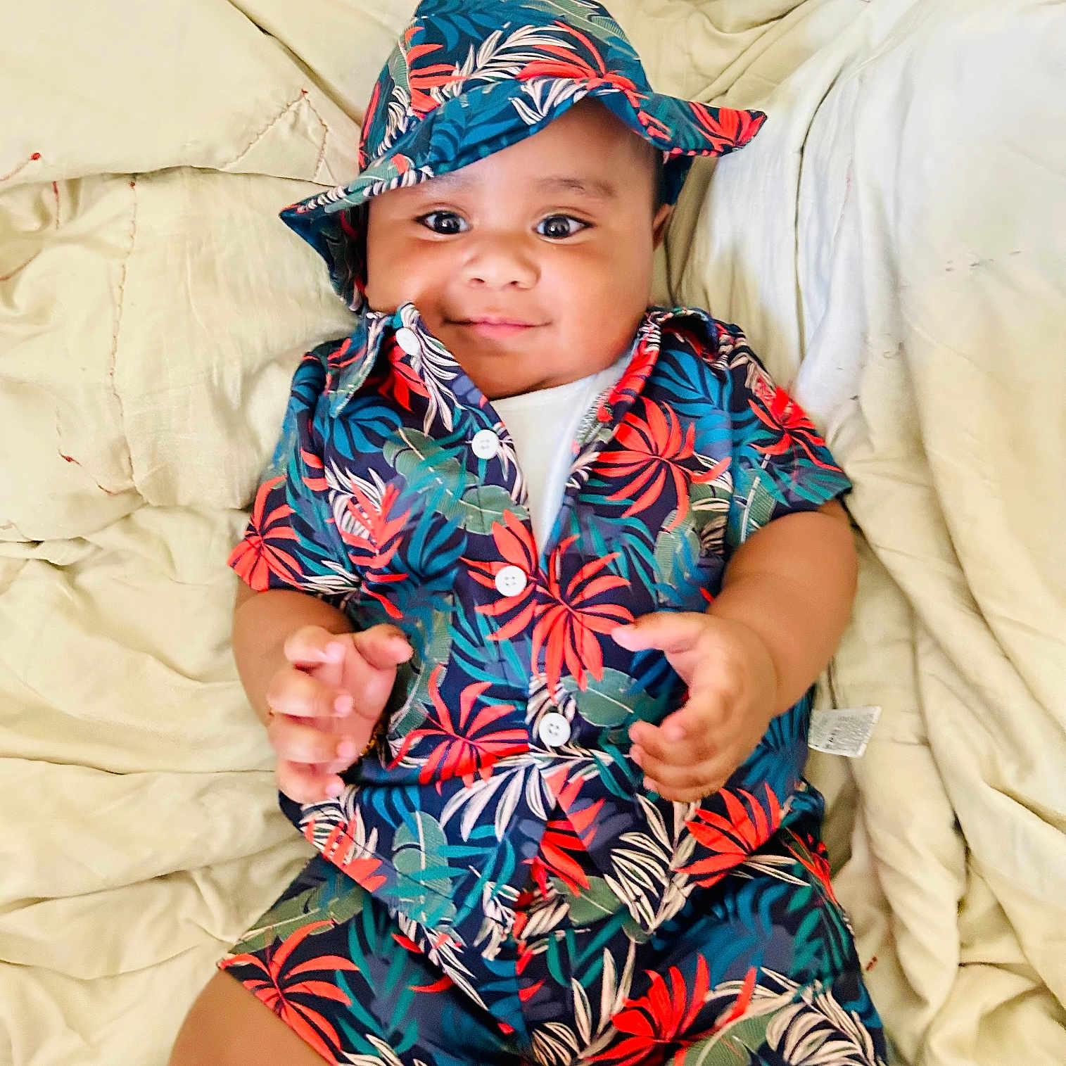 Mikea joined the competition — help win amazing prizes! baby, blanket, child, colorful, comfortable, cute, eyes, fabric, face, hands, happy, hat, infant, lying_down, pattern, portrait, skin, smile, toddler, tropical_clothing