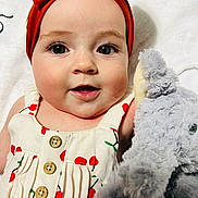 Lyla joined the competition — help win amazing prizes! baby, child, face, headband, red_bow, dress, cherry_pattern, stuffed_animal, toy, plush, eyes, skin, mouth, button, fabric, portrait, closeup, infant, cute, smiling