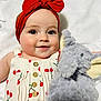 baby, child, headband, bow, plush_toy, elephant, smile, cherry_pattern, dress, button, face, cute, soft_toy, infant, closeup, portrait, happy, indoor, skin, white_background