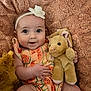 Lyla joined the competition — help win amazing prizes! baby, infant, smiling, headband, flower, plush_toy, bunny, blanket, orange_dress, cute, soft_texture, child, portrait, hand, legs, happy, cozy, indoor, furniture, comfort