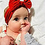 Lyla is registered to the contest to win money with this photo: baby, infant, child, headband, orange_bow, hand, thumb_in_mouth, curious_eyes, cherry_pattern, clothing, soft_blanket, plush_toy, cute, portrait, close_up, skin, face, indoors, comfortable, adorable