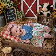 Magnolia joined the competition — help win amazing prizes! baby, child, infant, smiling, portrait, floral_dress, pink_bow, denim, wooden_wagon, rustic, farm, barn, plush_cow, chick, flowers, hay, blanket, outdoor, farmhouse, photography