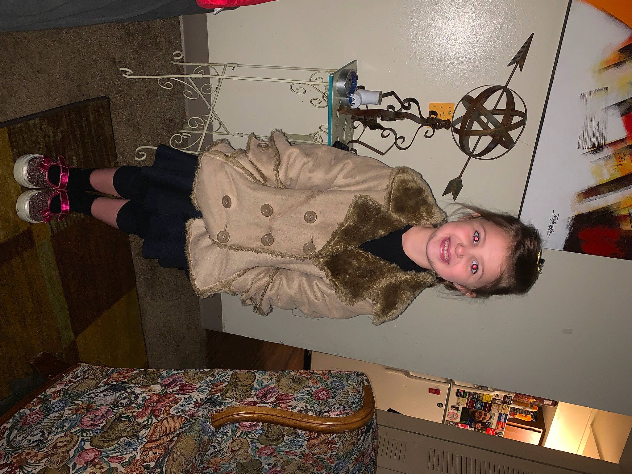 Kennedy is registered to the contest to win money with this photo: art, ceiling, comfort, couch, fun, interior_design, joy, linens, pattern, person, picture_frame, room, shelf, smile, t_shirt, textile, tire, tree, visual_arts, wood