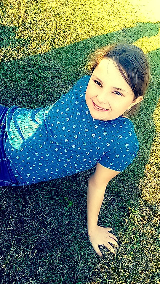 Paislee is registered to the contest to win money with this photo: azure, cool, electric_blue, flash_photography, fun, grass, grassland, happy, human_leg, joy, leisure, meadow, pattern, people_in_nature, person, plant, smile, standing, sunlight, thigh