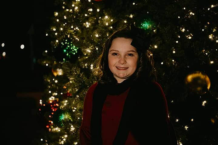 Paislee is registered to the contest to win money with this photo: branch, christmas_decoration, christmas_ornament, christmas_tree, electricity, event, eye, facial_expression, flash_photography, fun, hair, happy, human_body, joy, lighting, midnight, ornament, people_in_nature, person, plant