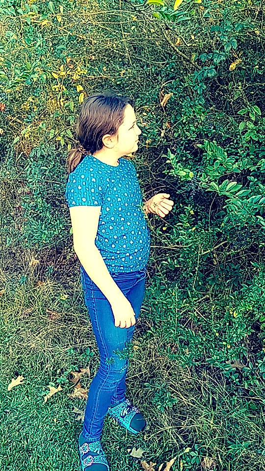 Paislee is registered to the contest to win money with this photo: arm, electric_blue, fun, grass, grass_family, grassland, hair, hairstyle, happy, human_leg, knee, long_hair, meadow, natural_environment, pattern, people_in_nature, person, plant, textile, thigh