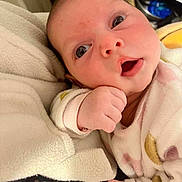 Derine participe au concours pour gagner de l'argent avec cette photo : baby, blanket, child, closeup, clothing, cute, expression, face, hand, indoors, infant, newborn, person, portrait, resting, skin, sleepwear, small, soft, warm