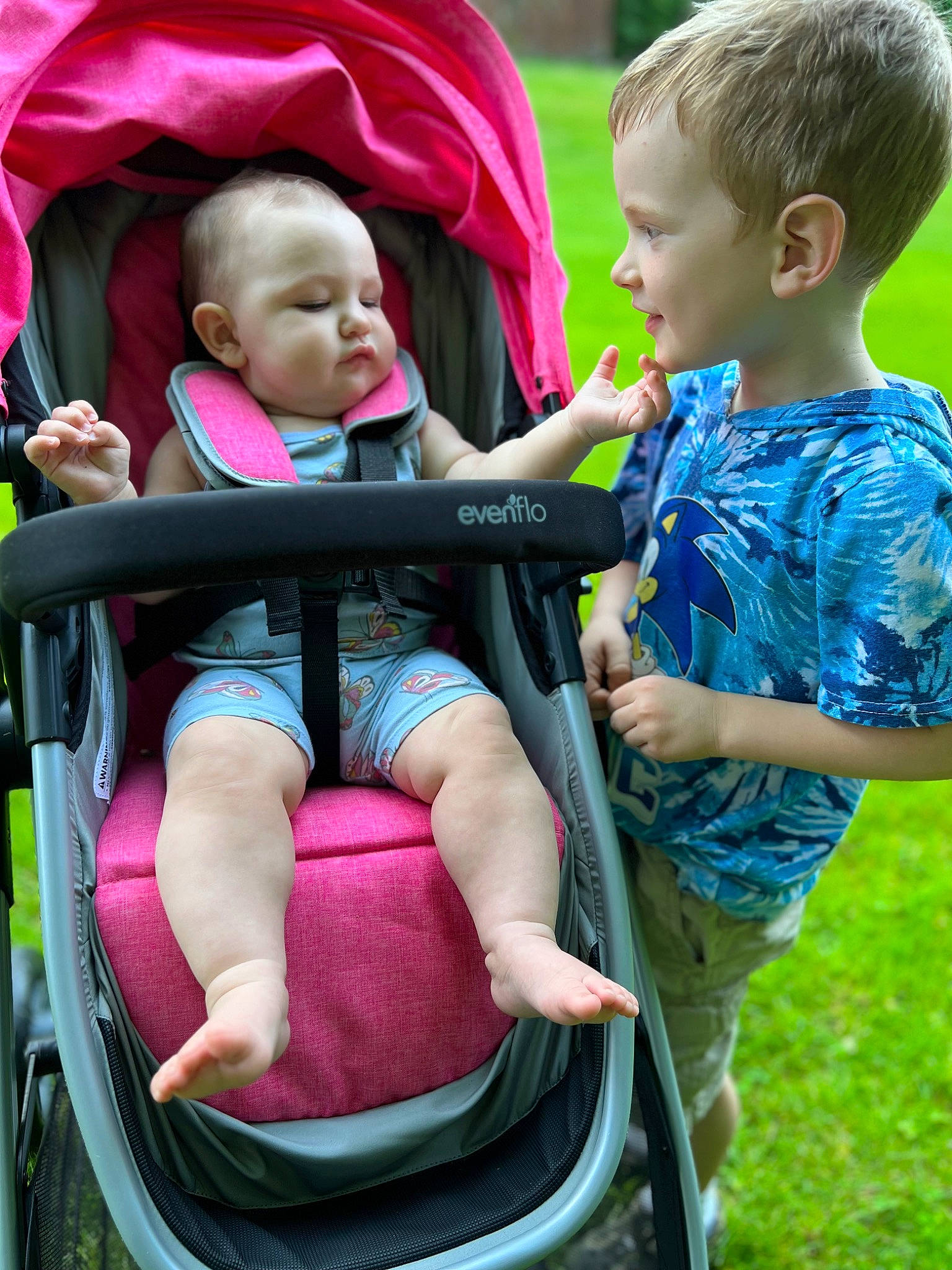 Gracie is registered to the contest to win money with this photo: baby, baby_carriage, baby_toddler_clothing, child, comfort, facial_expression, fun, grass, green, happy, lap, leisure, people_in_nature, person, photograph, public_space, recreation, red, style, summer