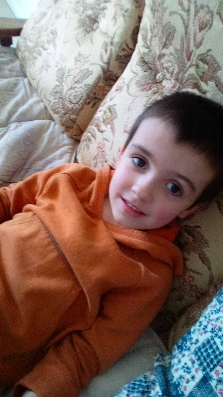 Grégory participe au concours pour gagner de l'argent avec cette photo : brown_hair, cheek, chest, child, comfort, flash_photography, flooring, fur, happy, joy, linens, lip, nose, person, portrait_photography, sitting, skin, sleeve, smile, textile