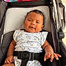 Izlyn is registered to the contest to win money with this photo: baby, baby_clothing, black_hair, bunny_print, child, colorful, curly_hair, cute, fabric, floral_pattern, hand, indoor, infant, onesie, portrait, relaxed, seatbelt, sitting, smile, stroller