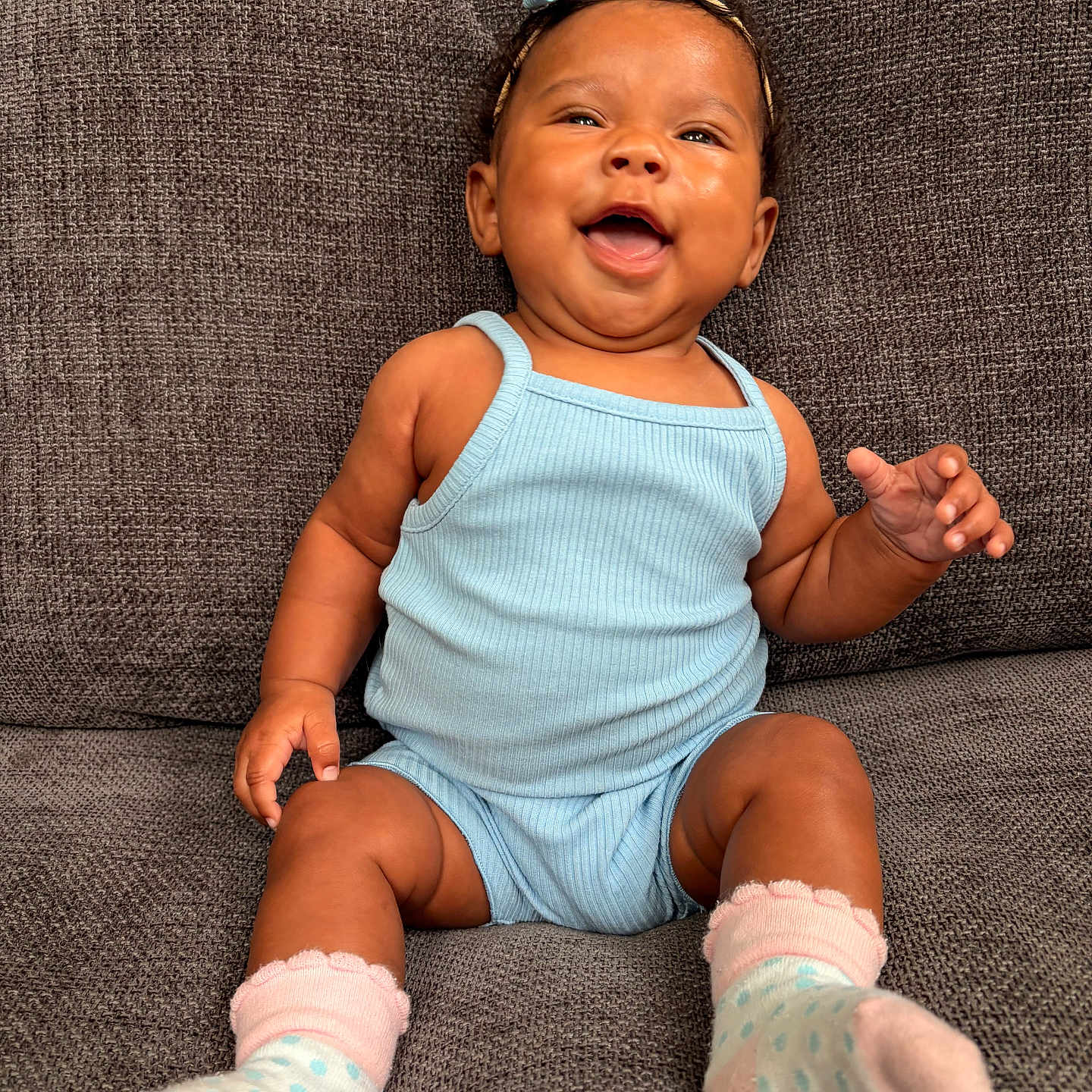Izlyn is registered to the contest to win money with this photo: baby, blue_clothing, bow, child, couch, cozy, cute, expression, furniture, happy, headband, indoor, infant, person, polka_dots, portrait, sitting, skin, smiling, socks