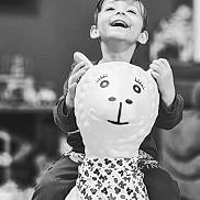 Nohlan a rejoint le concours — aidez-le/la à gagner de superbes lots ! child, toy, llama, bandana, smile, happy, indoor, play, pattern, clothing, face, hands, laugh, kid, background_blur, monochrome, portrait, fun, cute, joy