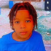 Kevin Alexandro is registered to the contest to win money with this photo: child, portrait, outdoor, courtyard, blue_shirt, braids, twists, black_hair, face, person, looking_at_camera, calm, t_shirt, brick_wall, concrete, building, daylight, smartphone_screenshot, social_media, colorful