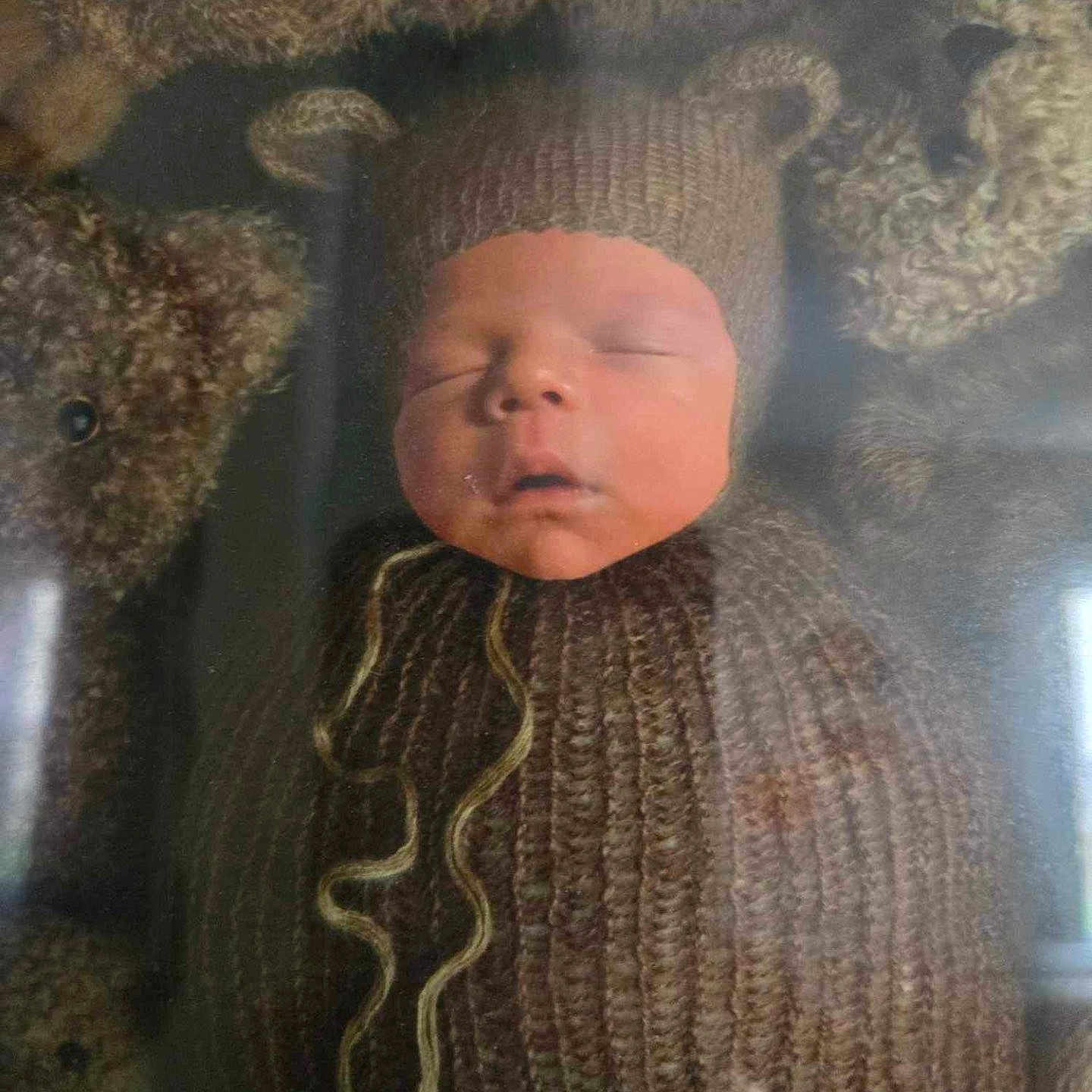 Amari is registered to the contest to win money with this photo: animal, baby, bed, bonnet, cap, clothing, couch, face, furniture, hat, head, knitwear, newborn, person, photography, portrait, sleeping, sweater, teddybear, toy