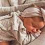 baby, sleeping, newborn, headband, knitted_clothing, blanket, closeup, peaceful, soft_texture, infant, cute, resting, cozy, portrait, child, skin, face, hand, sleep, relaxation