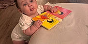 Joanna joined the competition — help win amazing prizes! baby, bathroom, bed, blanket, board_book, child, doorway, expression, face, floor, household_items, indoor, lighting, person, room, standing, tongue_out, toy, white_clothing, wood_floor