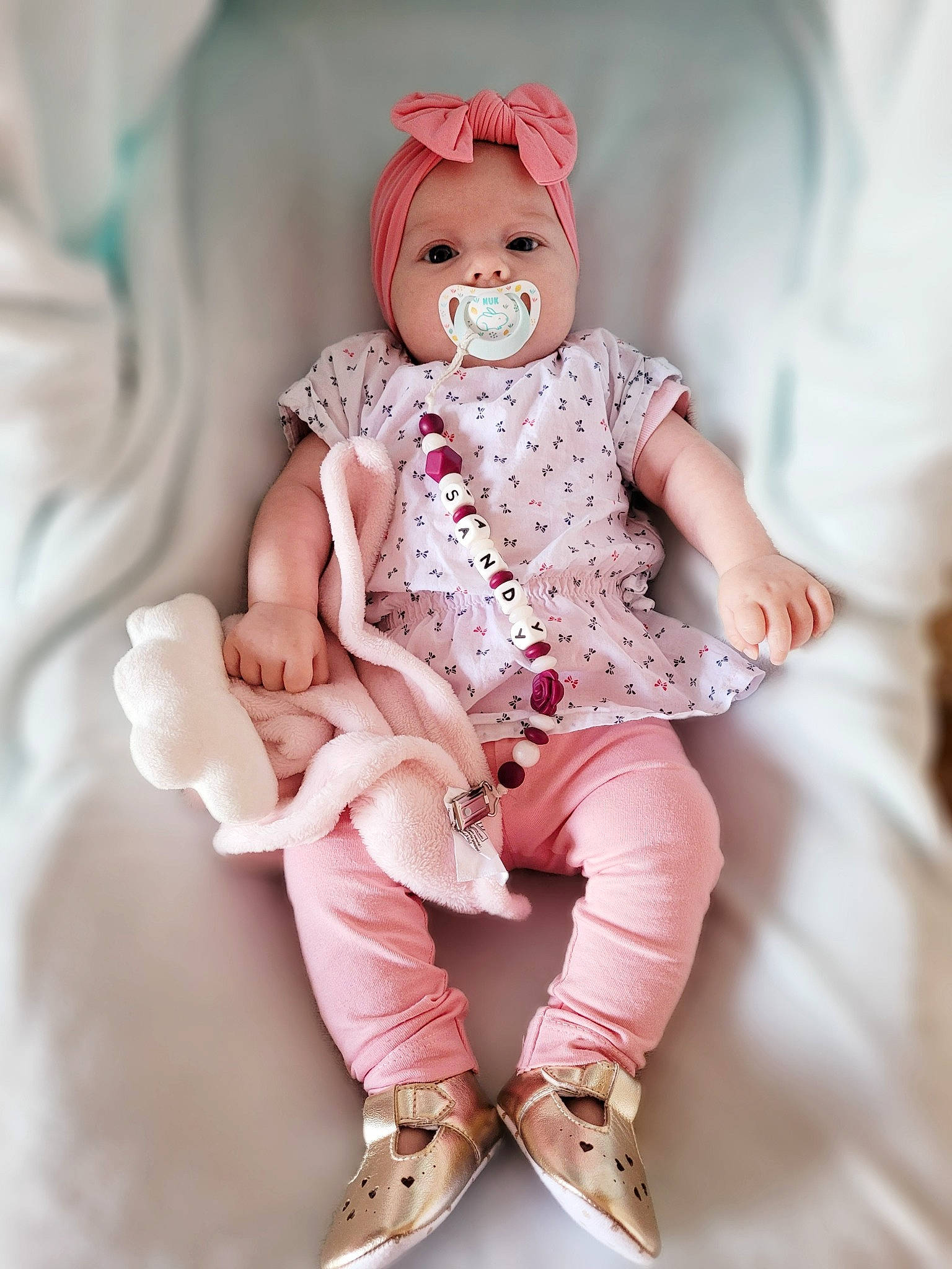 Sandy a rejoint le concours — aidez-le/la à gagner de superbes lots ! arm, baby_toddler_clothing, doll, eyelash, face, fashion_design, happy, headwear, human_body, leg, peach, person, pink, shoe, sitting, sleeve, smile, sock, thigh, toy