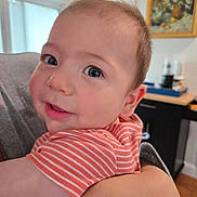 Jason is registered to the contest to win money with this photo: baby, child, person, face, eyes, smile, indoor, striped_shirt, arm, hand, holding, portrait, curly_hair, skin, close_up, background, painting, furniture, window, light
