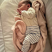 Victoria participe au concours pour gagner de l'argent avec cette photo : baby, sleeping, blanket, striped_clothing, infant, cozy, soft_texture, cushion, peaceful, foot, hand, face, indoors, portrait, child, resting, newborn, cute, comfortable, wrapped