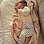 baby, sleeping, blanket, striped_clothing, infant, cozy, soft_texture, cushion, peaceful, foot, hand, face, indoors, portrait, child, resting, newborn, cute, comfortable, wrapped