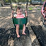 toddler, child, swing, playground, outdoor, smiling, happy, green_swing, wood_chips, bench, summer, sunlight, grass, trees, person, fun, play, barefoot, casual_clothing, daytime