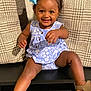 Jayciona joined the competition — help win amazing prizes! baby, blue_bow, brown_skin, child, couch, cushions, cute, dress, floral_pattern, happy, indoor, open_mouth, playful, portrait, shoes, shorts, sitting, smiling, toddler, young_child