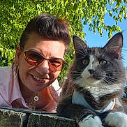 Bounty participe au concours pour gagner de l'argent avec cette photo : woman, cat, outdoor, greenery, blue_sky, sunglasses, hoop_earrings, smiling, fluffy_cat, wooden_surface, portrait, pet, nature, sunlight, happy, closeup, face, fur, animal, casual