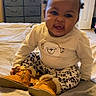 baby, child, infant, cute, smiling, sitting, bed, boots, clothing, patterned_pants, bear_print, window, dresser, indoors, room, hair, expression, person, cozy, playful