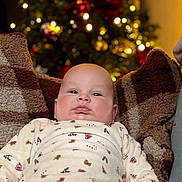 Gabriel participe au concours pour gagner de l'argent avec cette photo : baby, blanket, child, christmas_tree, comfort, cozy, cute, face, festive, holiday, indoors, infant, lights, person, plush, portrait, relaxing, sleepwear, soft, warm