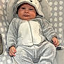 Gabriel a rejoint le concours — aidez-le/la à gagner de superbes lots ! baby, infant, onesie, hood, gray, fuzzy_clothing, animal_costume, baby_chair, patterned_fabric, leaf_pattern, cute, child, seated, indoor, soft_texture, calm_expression, small_hands, footed_pajamas, zipper, plush
