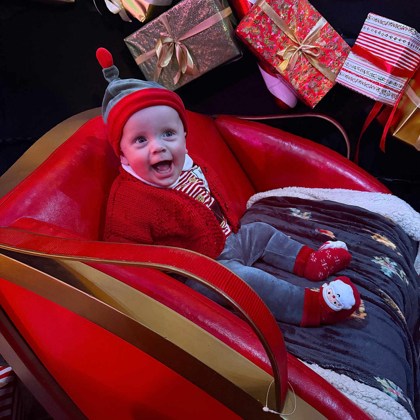 Noah joined the competition — help win amazing prizes! baby, blanket, celebration, child, christmas, cozy, cute, festive, gift_wrap, happy, hat, holiday, indoor, portrait, presents, red_clothing, seasonal, sleigh, smiling, socks