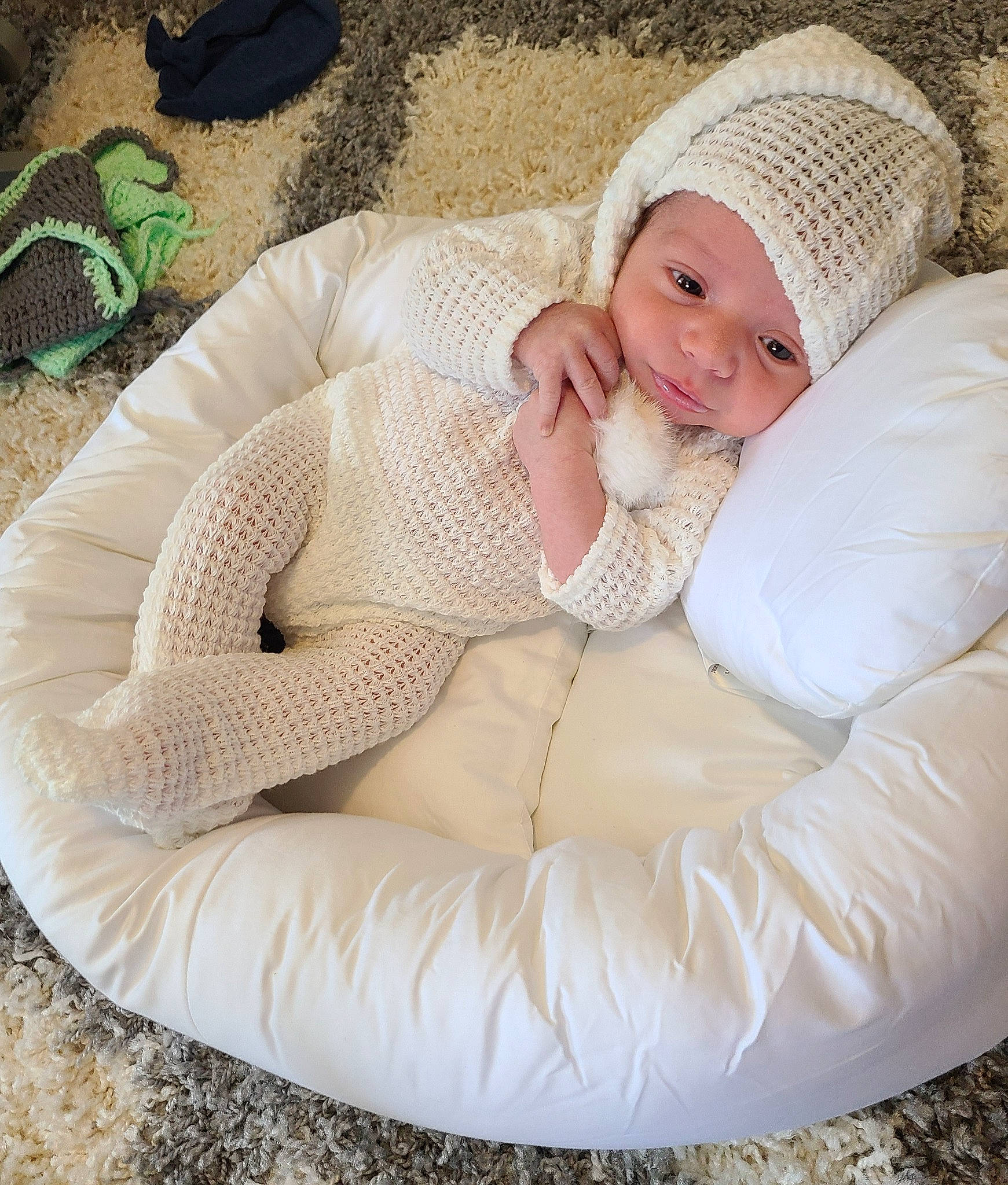 Christopher John joined the competition — help win amazing prizes! baby, baby_sleeping, baby_toddler_clothing, bean_bag, cap, comfort, face, grass, green, happy, head, headwear, human_body, knit_cap, lap, pattern, person, sitting, smile, toddler