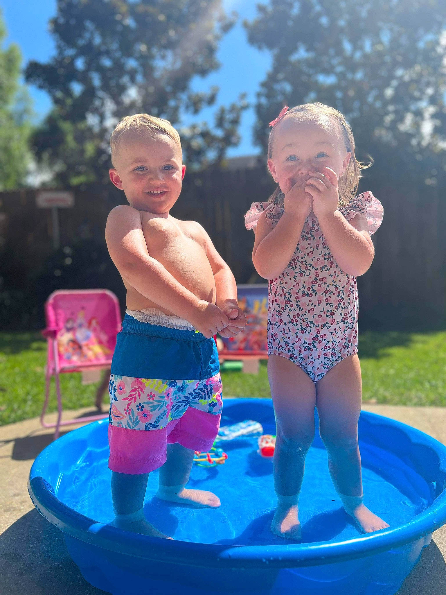 Anthony Jameson is registered to the contest to win money with this photo: barefoot, bathing, child, electric_blue, facial_expression, fun, grass, happy, joy, leisure, people, person, pink, plant, recreation, sky, smile, swimwear, thigh, toddler