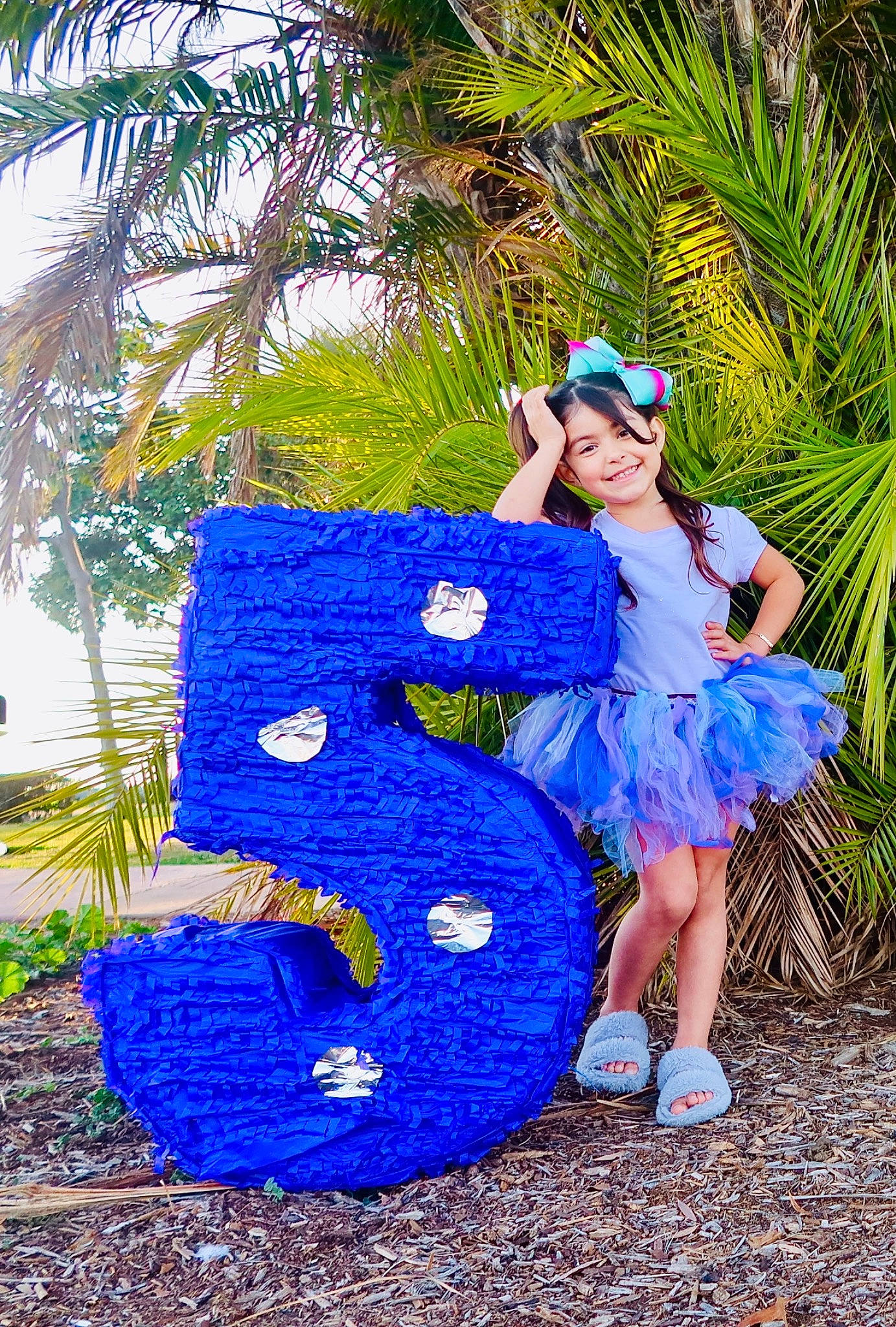 Chloe is registered to the contest to win money with this photo: arecales, azure, blue, costume, dress, electric_blue, event, feather, formal_wear, fun, garden, grass, happy, joy, leisure, palm_tree, people_in_nature, person, plant, recreation