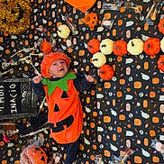Inacio participe au concours pour gagner de l'argent avec cette photo : baby, black, blanket, candy, celebration, cute, decorations, face, festive, floor, halloween, holiday, holiday_decoration, infant, orange, pumpkin_costume, seasonal, smiling, toy, white