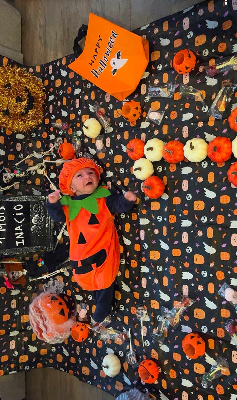 Inacio participe au concours pour gagner de l'argent avec cette photo : baby, black, blanket, candy, celebration, cute, decorations, face, festive, floor, halloween, holiday, holiday_decoration, infant, orange, pumpkin_costume, seasonal, smiling, toy, white