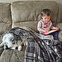 toddler, dog, blanket, couch, tablet, child, indoor, plaid, sleeping, pet, cozy, casual_clothing, soft_lighting, curly_hair, playing, relaxation, animal, furniture, calm, technology