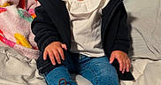 Amelia is registered to the contest to win money with this photo: child, baby, toddler, smiling, portrait, sitting, bed, bedroom, blanket, pillow, bow, headband, leopard_print, jacket, shirt, jeans, shoes, fashion, indoors, happy
