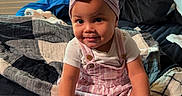 Amelia is registered to the contest to win money with this photo: baby, bed, bedroom, blanket, blinds, bow, child, fashion, happy, headband, indoor, overalls, pink_outfit, portrait, shirt, sitting, smiling, sneakers, toddler, window