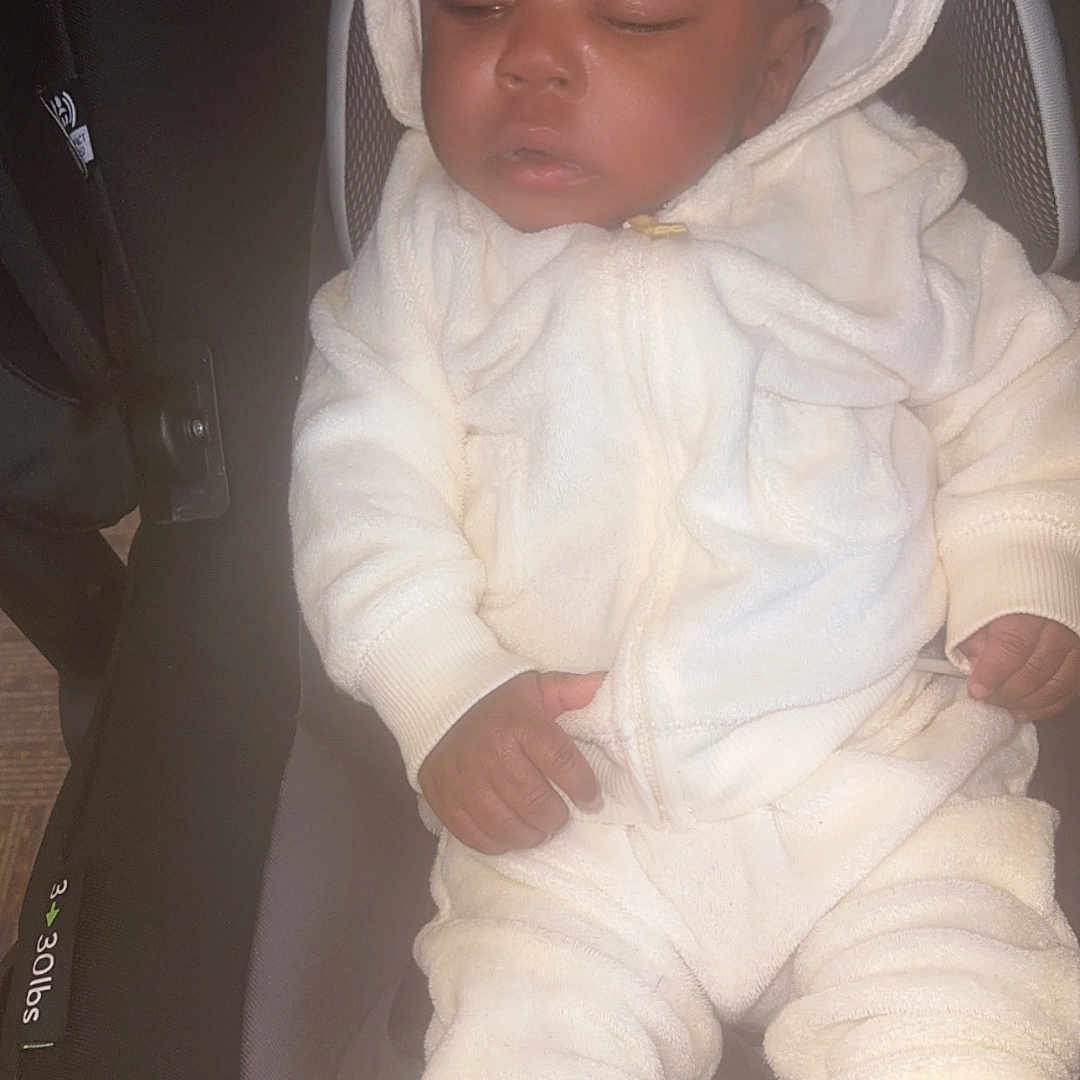 Teangelo is registered to the contest to win money with this photo: baby, brown_booties, car_seat, child, cozy, cute, footwear, hooded_outfit, indoors, infant, peaceful, portrait, relaxed, resting, seat, sleeping, soft_fabric, toddler, white_clothing, young_child