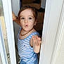 beaded_necklace, blue_clothing, casual_wear, child, curious, cute, doorway, expression, face, hand, house, indoors, person, portrait, short_hair, skin, stairs, striped_clothing, toddler, young_child