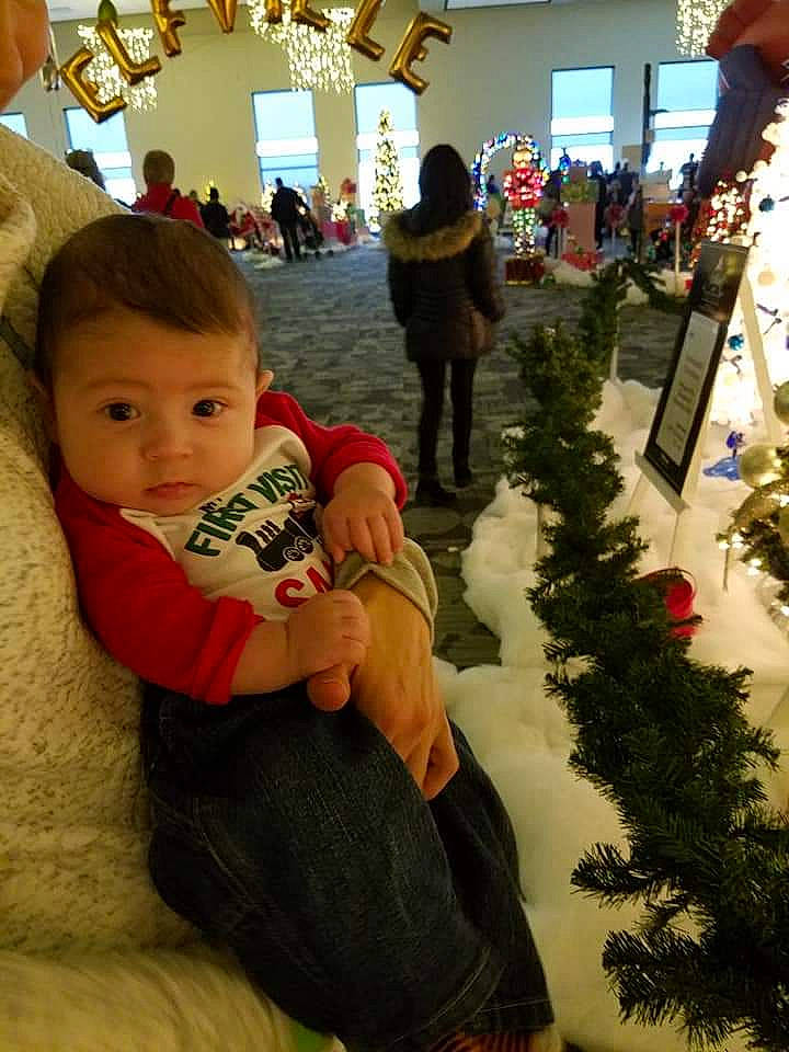 Leland is registered to the contest to win money with this photo: child, christmas, event, fun, holiday, infant, person, product, toddler, tree, vertebrate