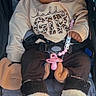 baby, child, infant, stroller, seated, portrait, face, bow, headband, sweatshirt, girl, fuzzy_boots, pacifier, toy, car_seat, harness, winter_clothing, fashionable, indoors, smiling